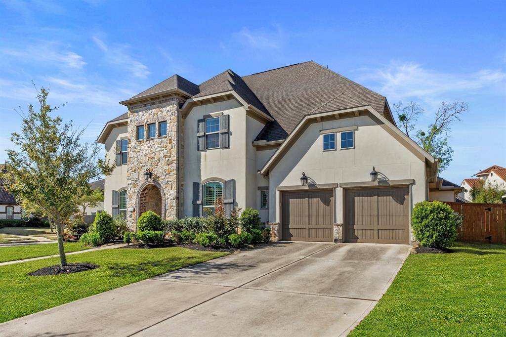 A picturesque view of this beautiful home’s exterior highlights the expansive driveway leading to the impressive tandem three-car garage. Lush landscaping and clean lines create an inviting atmosphere, setting the stage for the elegance found inside.