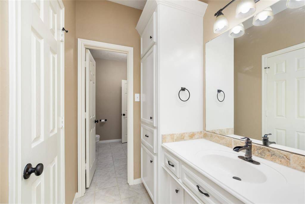 This secondary bathroom offers a clean, polished look with sleek white counters, custom cabinetry, and fresh paint completed in 2024. The elegant finishes create a bright and timeless space that’s perfect for both family and guests.