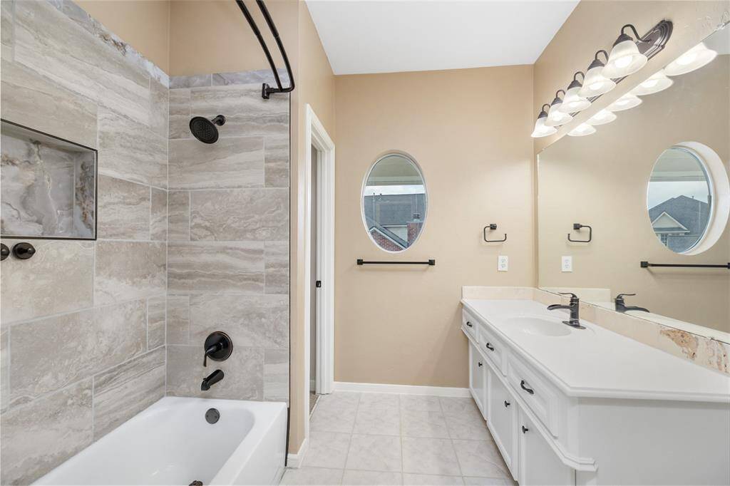 Sleek, stylish, and updated in 2024 with today’s finishes, the secondary bath serves as a polished retreat for guests or family. Durable tile flooring, a refined vanity, and a tub-shower combo offer both form and function in a calming palette.