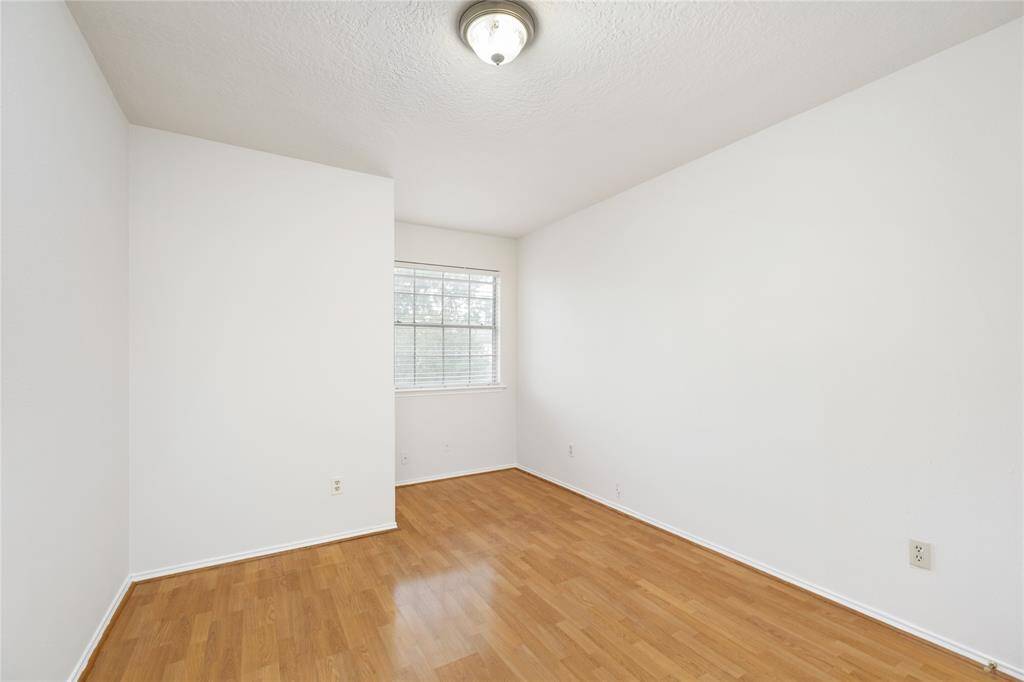 Bedroom 2 has high ceilings, a large window that faces the front of the home, and no carpet.