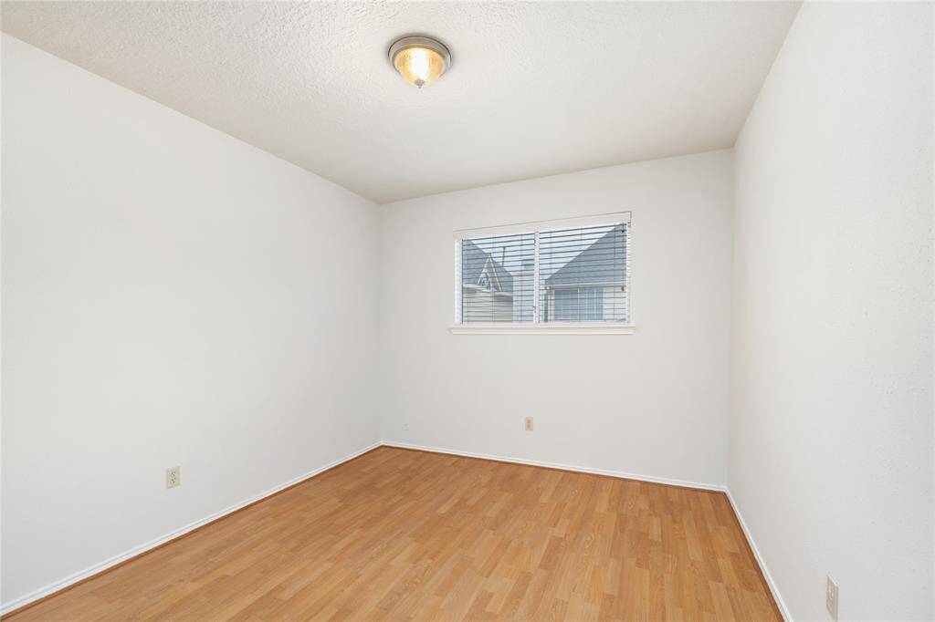 Bedroom 3 has high ceilings, a large window that faces the back of the home, and no carpet.