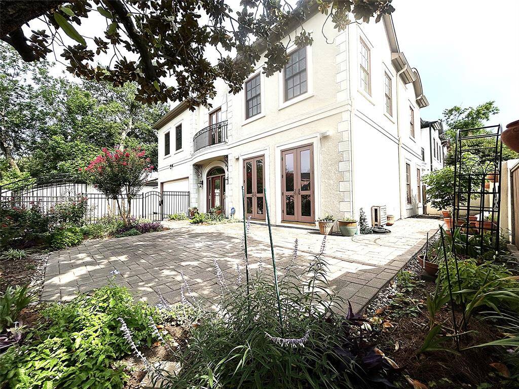 A shaded courtyard patio and grill area on the side, inside the stucco fence and garden area