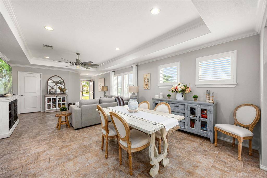This spacious living and dining area features a modern open layout with neutral tones, tile flooring, and an abundance of natural light.