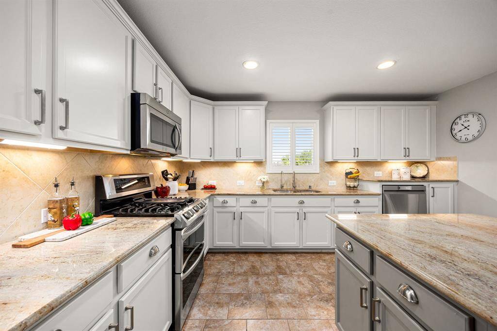 This view of the kitchen features the lovely window over the sink overlooking the back yard.