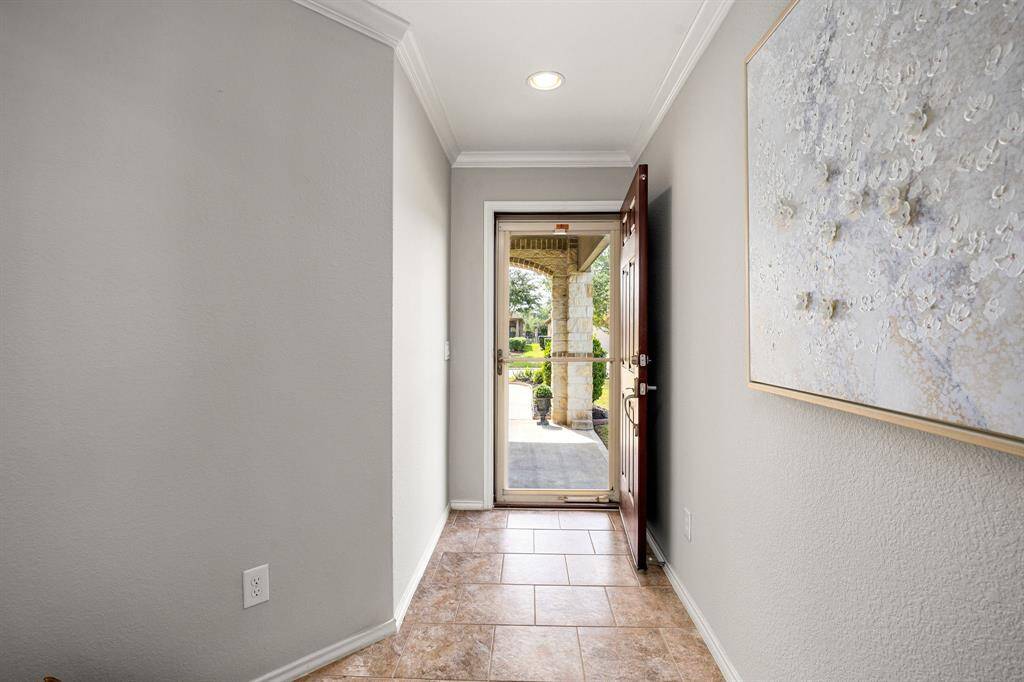 This photo shows the bright, welcoming entryway with neutral-toned walls and tile flooring.