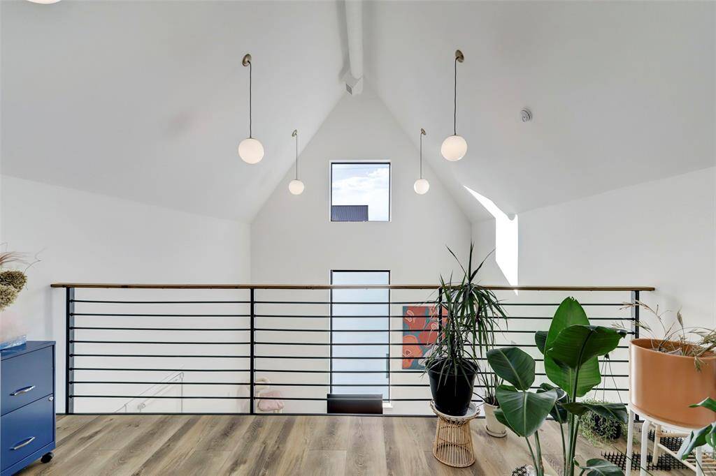Upstairs loft area overlooks the living area. Minimalist light fixtures don't take away from the impressive vaulted ceilings.