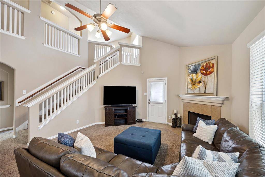 Expansive family room with ample space for relaxing and entertaining. The open layout flows effortlessly to the staircase leading upstairs, where a large game room awaits—perfect for gatherings, play, or a home office.