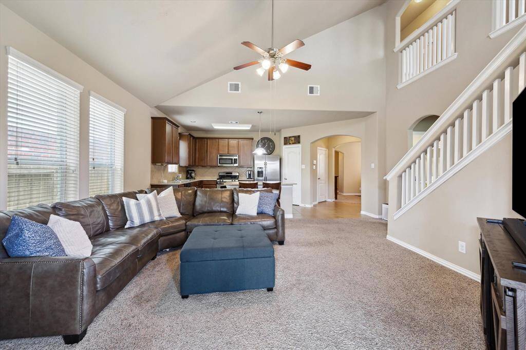 View from the family room showcases the open flow back to the spacious kitchen and formal dining area. This layout creates a bright, connected space ideal for family meals and entertaining guests.