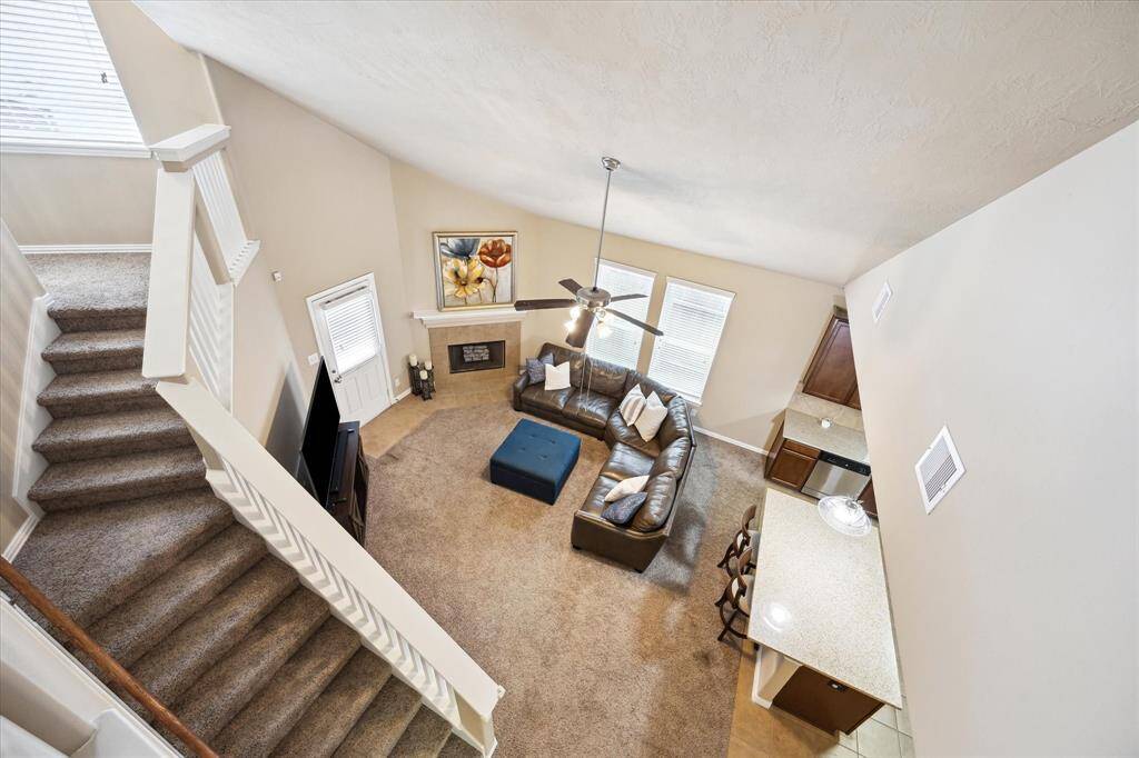 Looking down from upstairs, enjoy a stunning view of the spacious family room and kitchen below. The open-concept design with high ceilings creates an airy, welcoming atmosphere that connects both levels beautifully.