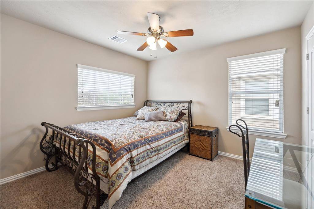 Another spacious secondary bedroom upstairs featuring a ceiling fan, two windows that fill the room with natural light, and a large closet for plenty of storage—ideal for family members or guests.