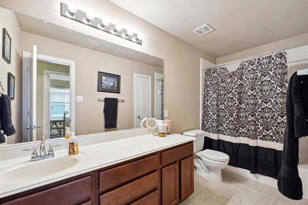 Spacious upstairs bathroom features an extra-large vanity with ample counter space and storage, designed to accommodate busy mornings and provide convenience for the whole family.