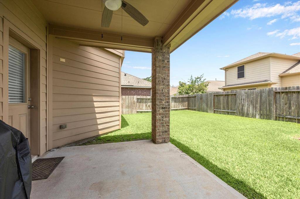 Covered back patio with ceiling fan.