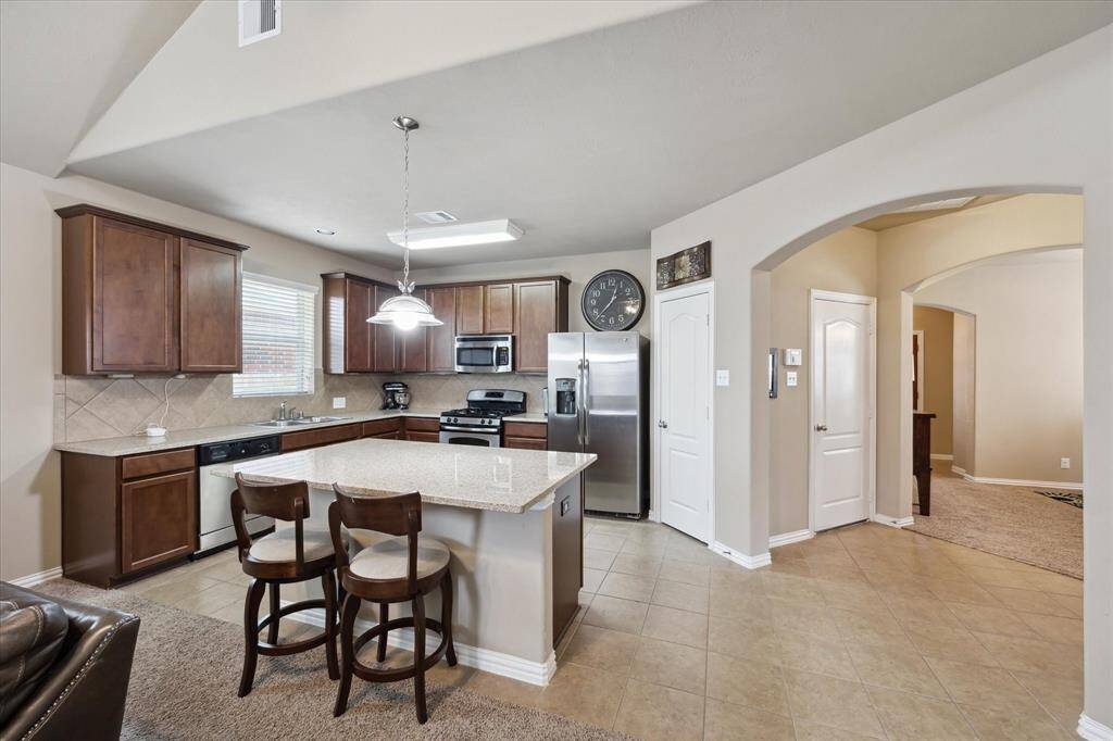 This large kitchen offers a central island, sleek granite countertops, and rich 42" cabinets. The open layout flows seamlessly into the family room, creating an ideal space for cooking, entertaining, and spending time with family. A perfect blend of style and function.