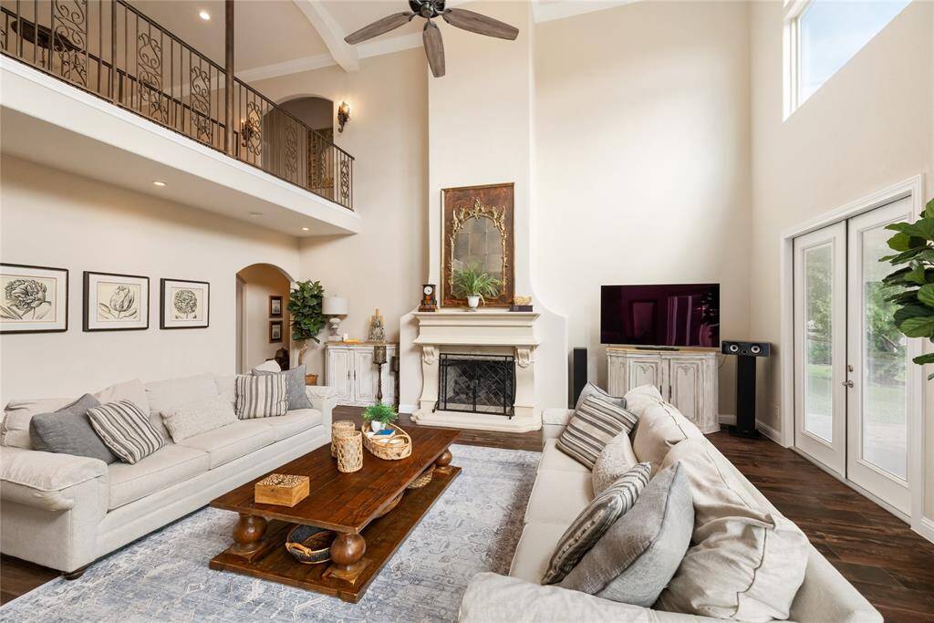 Gather around the stately fireplace for cozy evenings or elegant celebrations. With soaring ceilings and graceful arched windows offering serene views, this space invites both intimate moments and grand entertaining—all beneath the warmth of the fire’s glow.