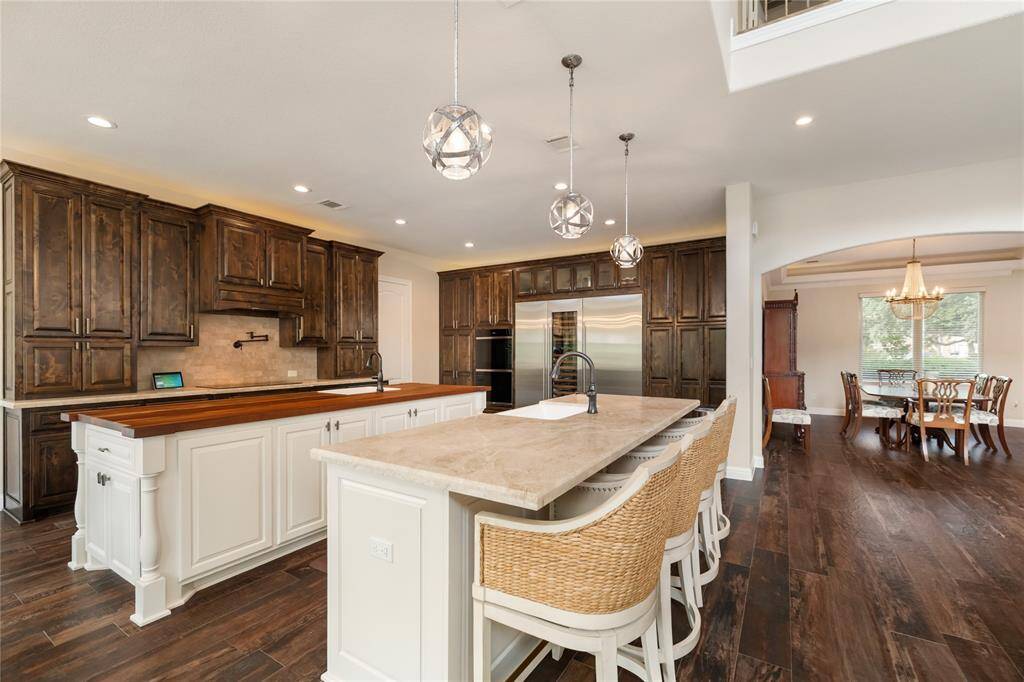 A chef’s dream with form and function in perfect harmony. Dual islands provide ample prep and serving space—one with a breakfast bar for casual dining—while elegant pendant lighting adds a refined touch to this culinary centerpiece.