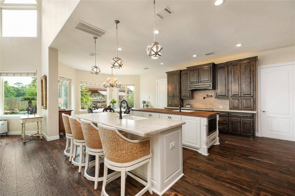 From the kitchen, enjoy a view of the bright breakfast nook surrounded by bay windows, flooding the space with natural light. Designed for both efficiency and elegance, the kitchen features dual islands, dual sinks, and a pot filler—ready for any culinary adventure.