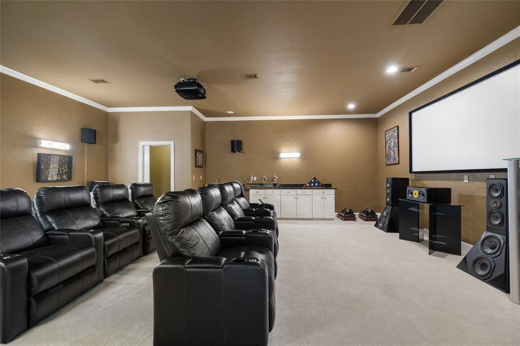Experience cinematic luxury in the impressive home theater, complete with a built-in bar, crown molding, and a high-quality projector system. Designed for elevated entertainment, this space combines comfort and class for the ultimate movie night or game day.