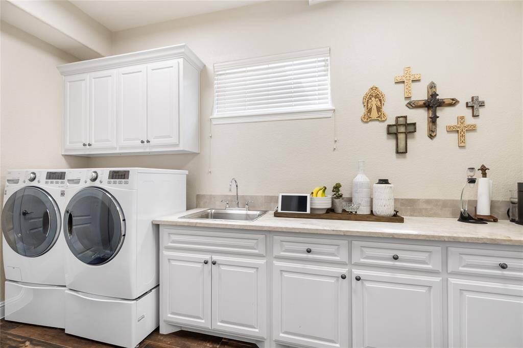 Even everyday tasks feel effortless in this expansive utility room. Thoughtfully designed with ample cabinetry, a spacious countertop, and a built-in sink, it offers both style and function in one beautifully organized space.