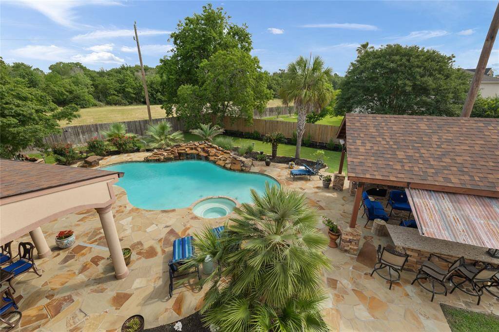 From above, the backyard reveals a thoughtfully designed entertainer’s paradise—complete with a resort-style pool and spa, covered flagstone patio, additional outdoor bar and kitchen, and lush green space. With so many areas to gather, relax, and celebrate, your home becomes the destination.
