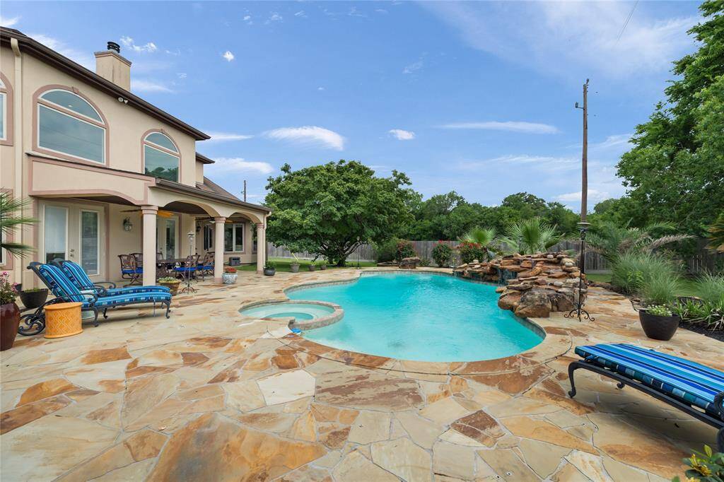 Imagine spending your days lounging under the covered patio, dining al fresco, or taking a refreshing dip in the pool while the gentle waterfall adds ambiance. Whether it's a lively summer gathering or a quiet morning swim, this space turns every moment into a luxury escape.