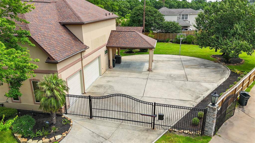 A gated driveway adds both convenience and peace of mind, offering enhanced security and privacy. It leads to a spacious three-car garage, a covered carport, and a wide driveway with ample room—perfect for extra parking or even your own private basketball setup.
