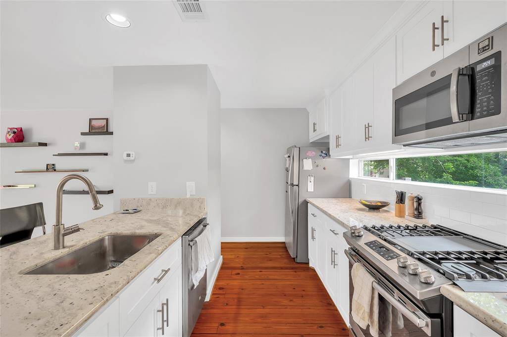 Another view of the updated kitchen. Gas range stovetop with griddle.