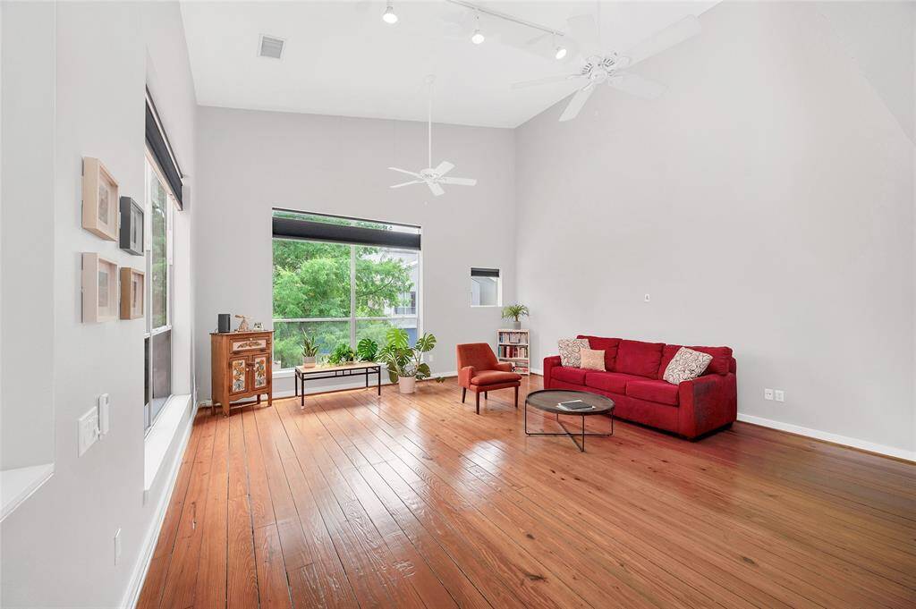 Another view of the spacious living room with custom window treatments. Comfort and style meet in this elegant space.