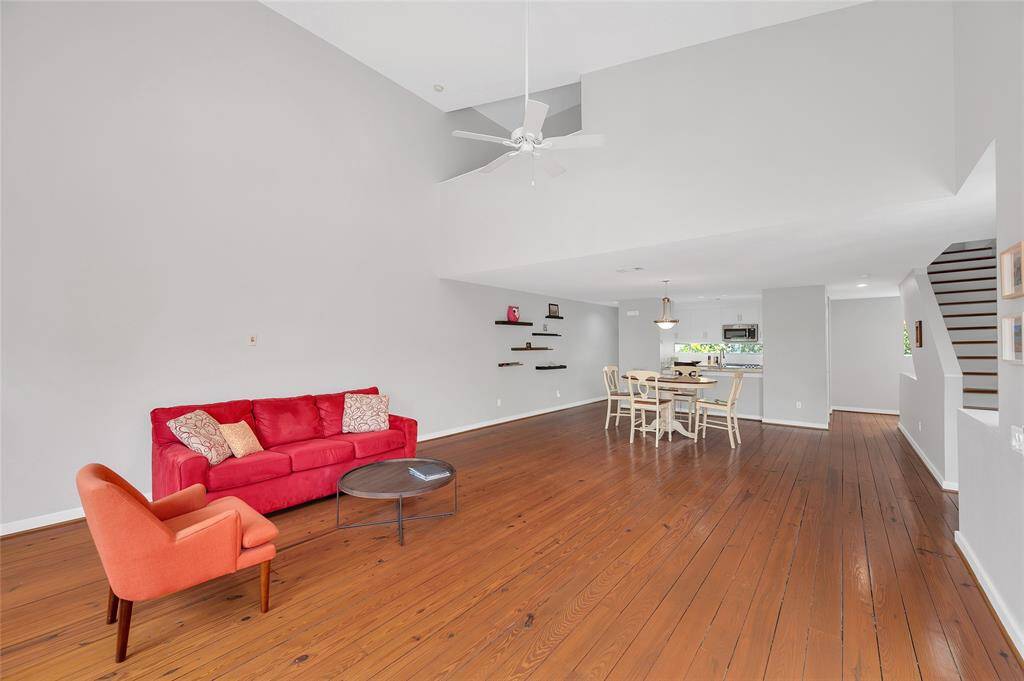 Living room with view of the dining room and kitchen. The stairs will greet you to the third floor and primary suite.