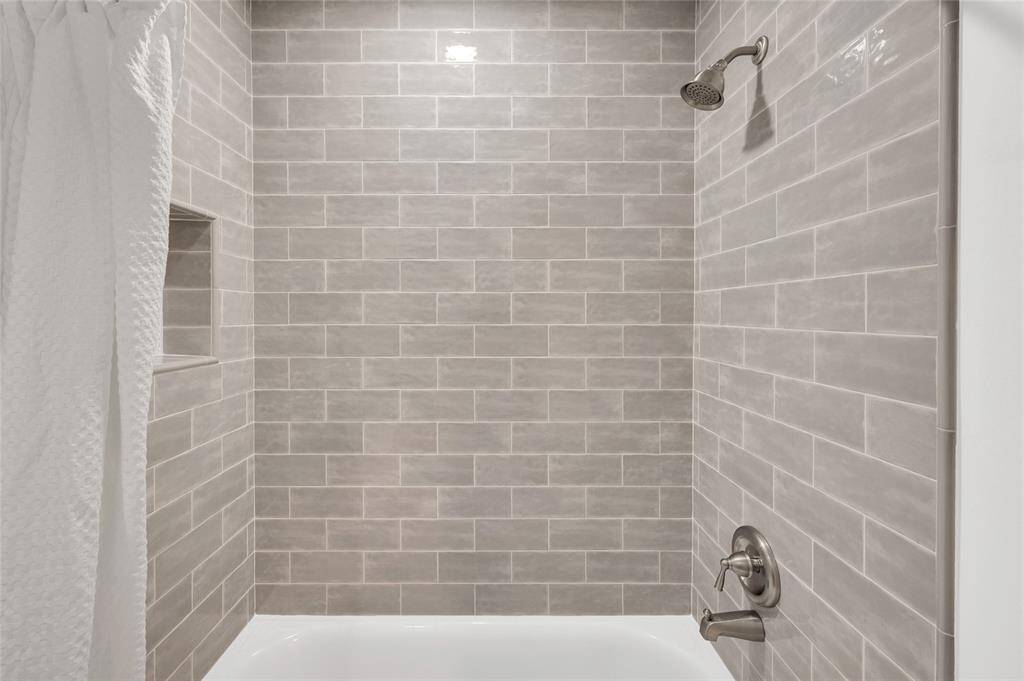 Sleek tile shower/tub combo.