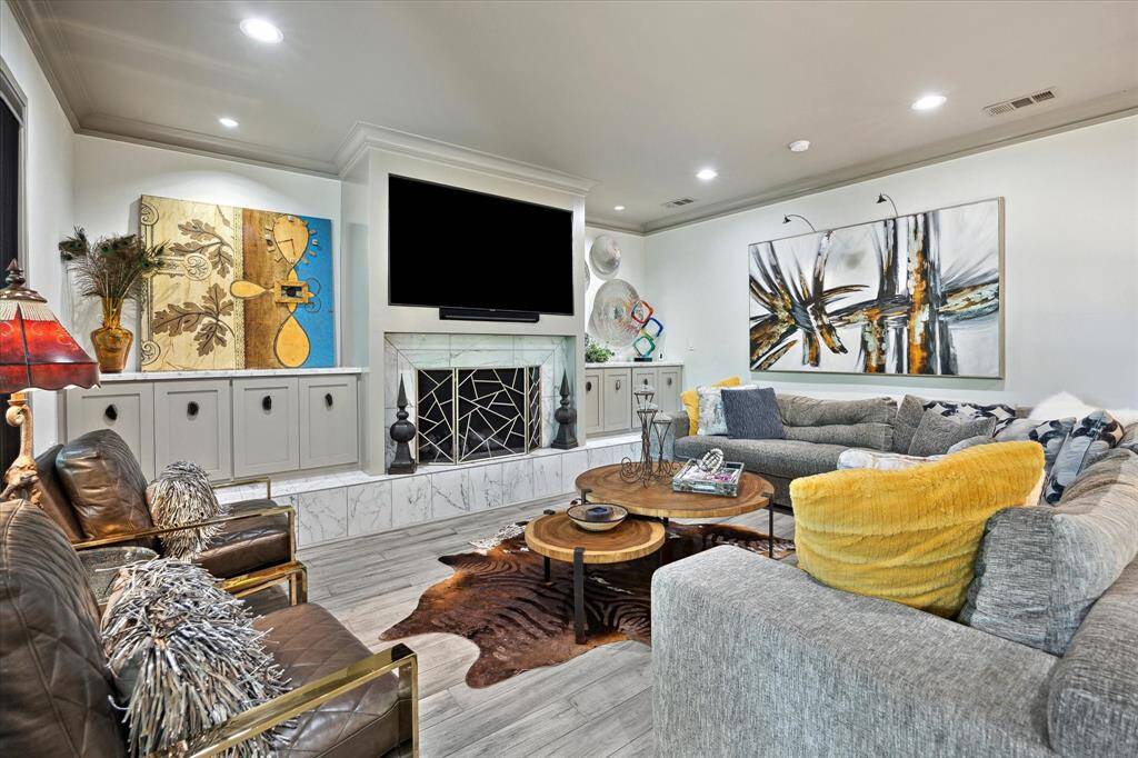 Large first floor living area with gas stone fireplace and built-ins.
