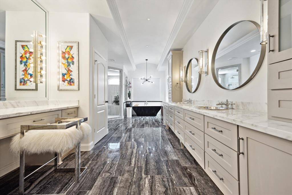 Stunning primary bath with soaking tub, separate shower, dual sinks, vanity area and large walk-in closet