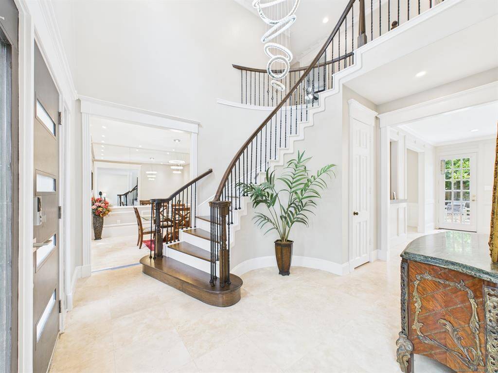 Inviting Formal Entry with Curved Staircase and High Ceilings