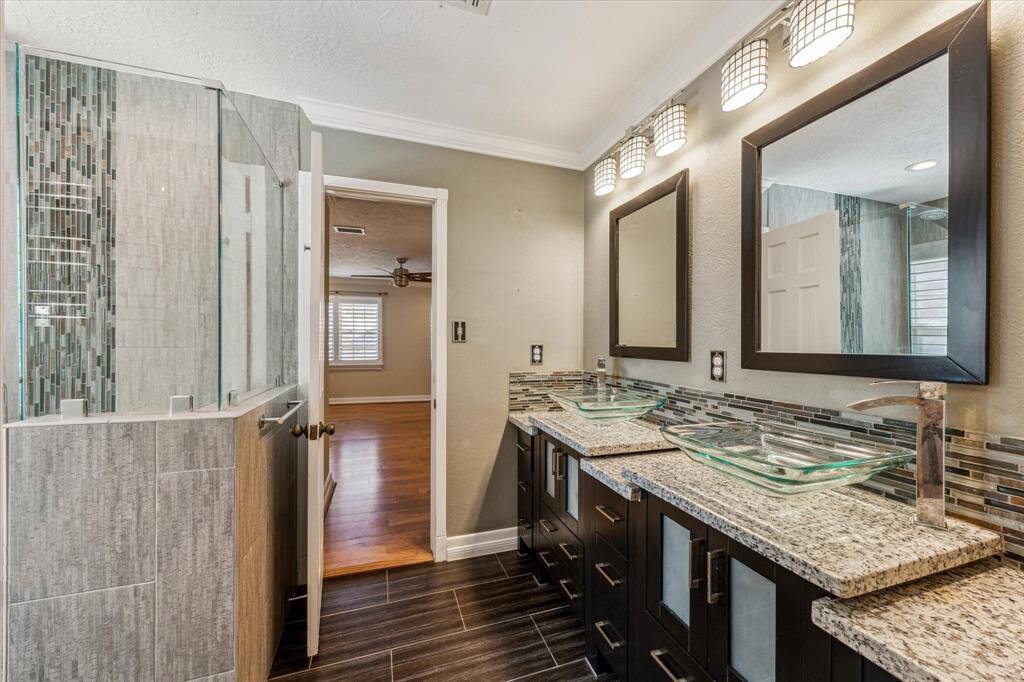 Stunning updated secondary bathroom with double sinks, heated towel rack and shower with body sprayers.
