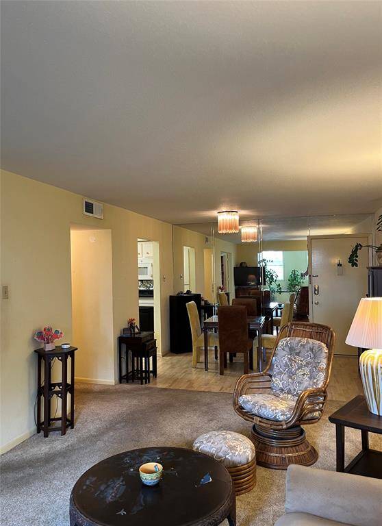 The 2nd View Of This Large Living Area.  Dining Is Combined With Wall To Wall Mirrors & Laminated Wood Flooring.