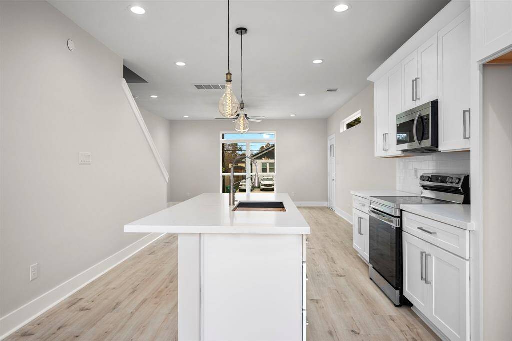 Kitchen with island and quartz countertops.