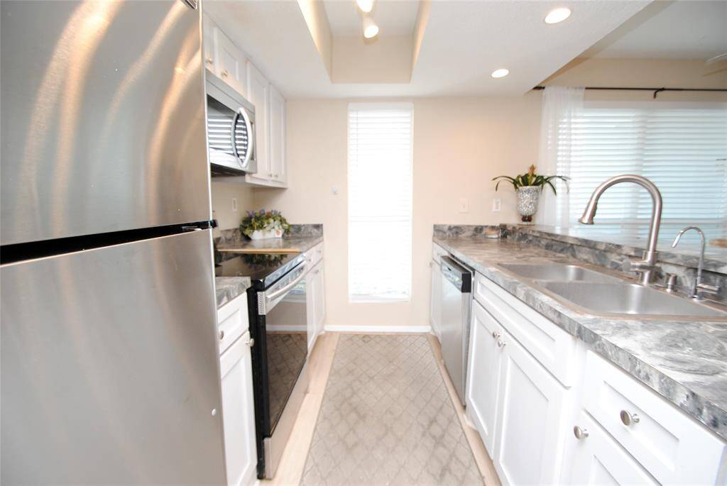 Light gray cabinetry surrounds open kitchen.