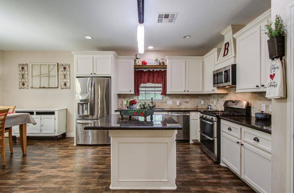 Kitchen has a really nice spacious granite island that can accommodate barstools to become a quick bite-to eat area and the space between island to kitchen countertops is wide and inviting, some kitchens have very narrow space between island and countertops, not here, it's really good spacing.