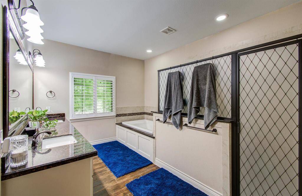 Spacious upgraded primary bath with separate elongated enclosed shower enclosure, separate jetted soaker tub and dual vanities.