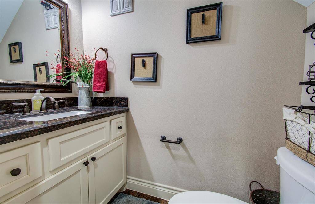 1st floor powder bath with full size vanity with drawers and cabinetry storage, decorative framed mirror and elongated toilet, nice to have a spacious accomidating half bath for Family, Guests and Visitors.