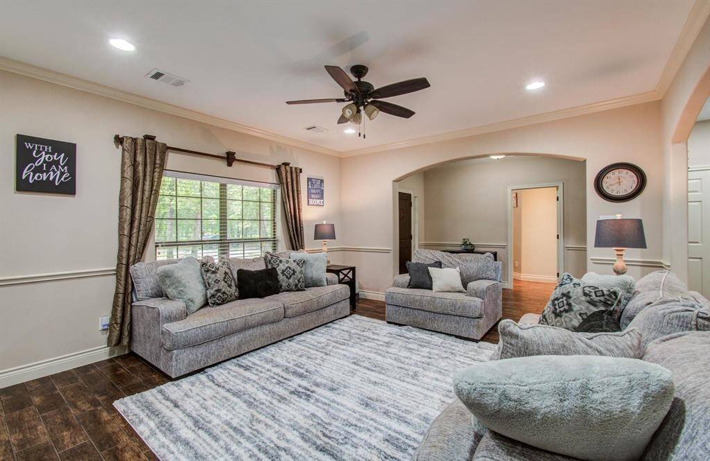 Large formal living with LED recessed lights, ceiling fan, upgraded crown molding surrounded by aesthetically pleasing arches.