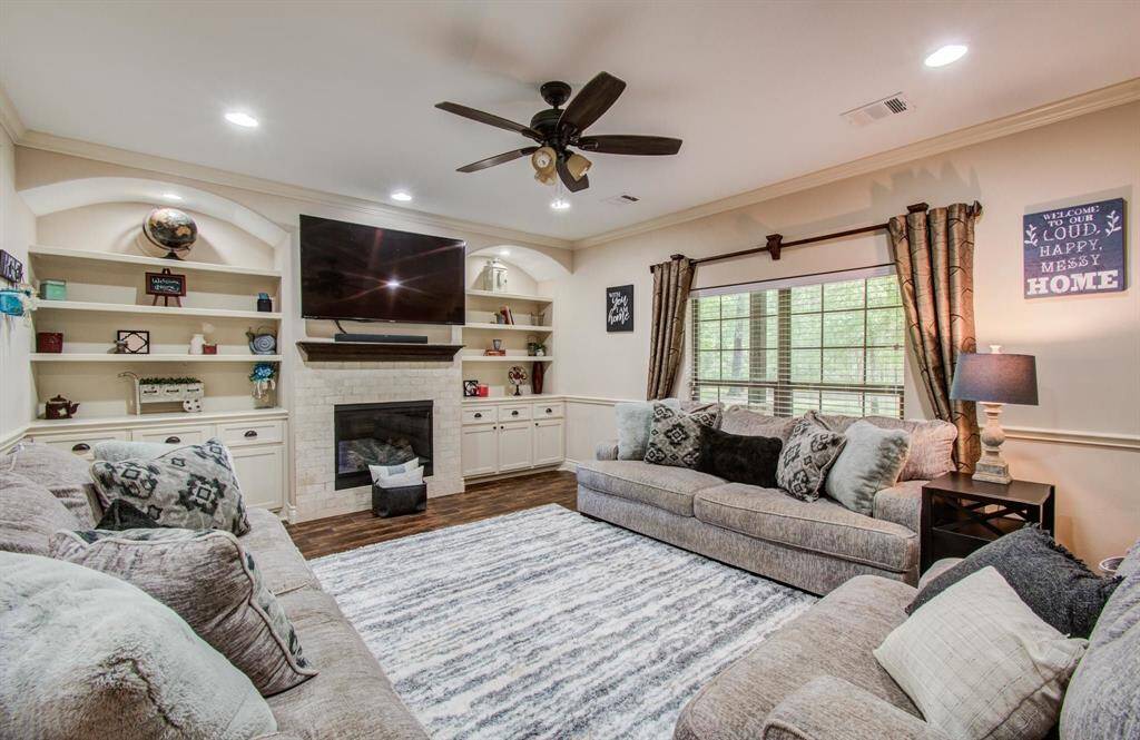 The spacious family room has been upgraded with good amounts of LED recessed lighting with beautiful built-in inspirational showcase shelving, decorative drawers and cabinetry that accentuate the center fireplace & mantel.