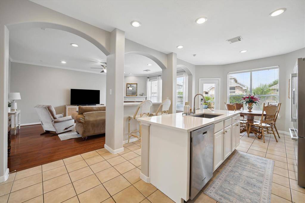 Designer kitchen remodeled in 2025 with new quartz countertops, painted cabinetry, island, and breakfast bar