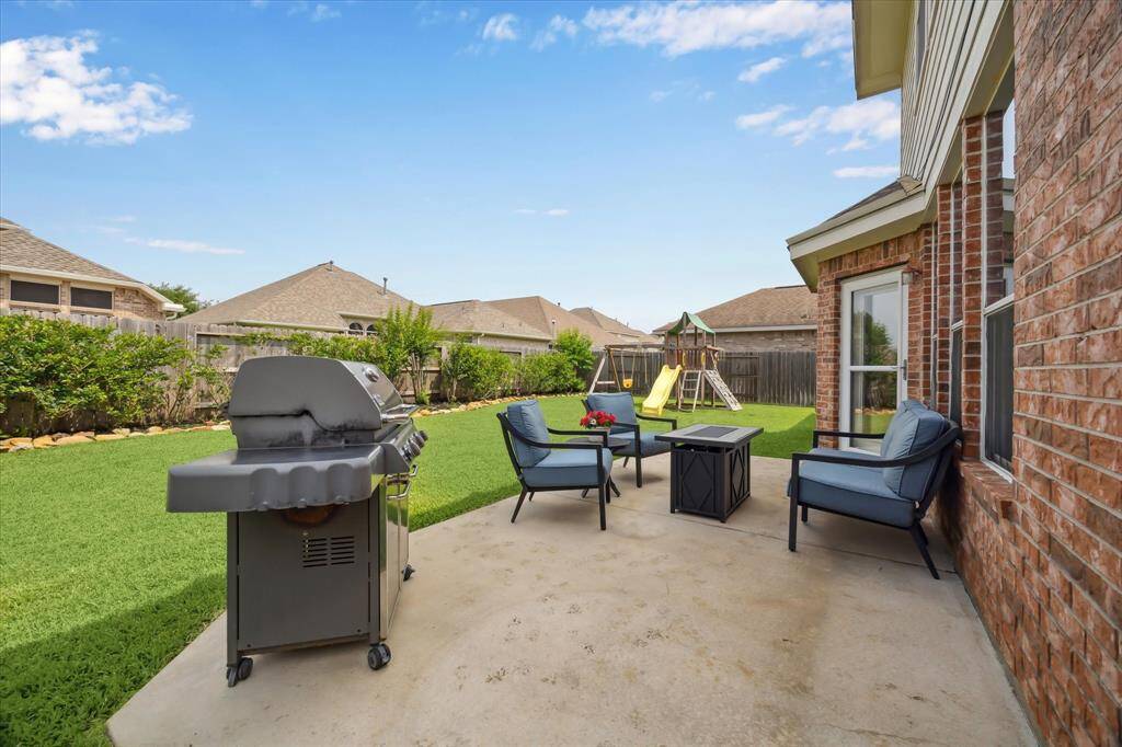 Professionally landscaped backyard features French drains (2023), mature trees, and an extended patio