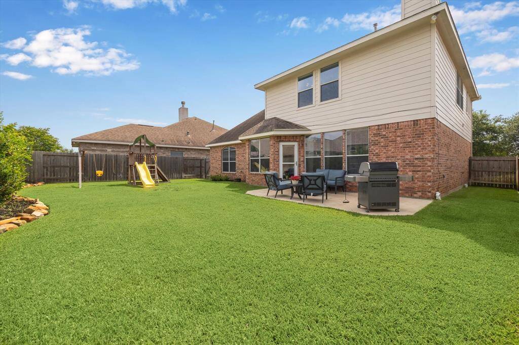 Professionally landscaped backyard features French drains (2023), mature trees, and an extended patio