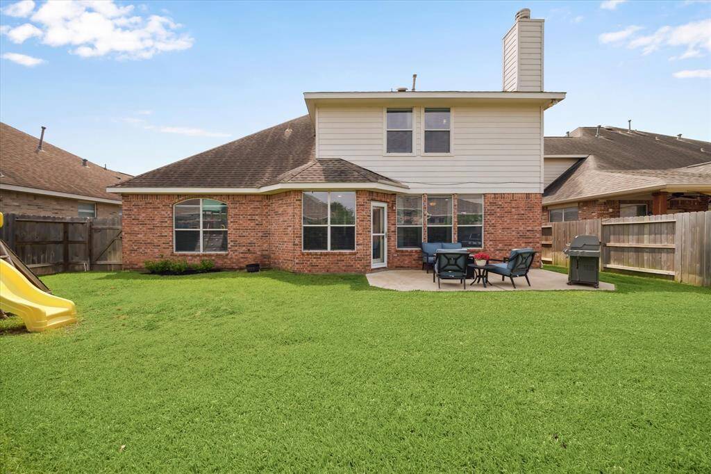 Professionally landscaped backyard features French drains (2023), mature trees, and an extended patio