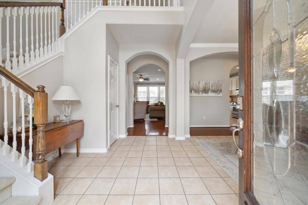 Grand foyer leads to formal dining and an expansive living room with fireplace