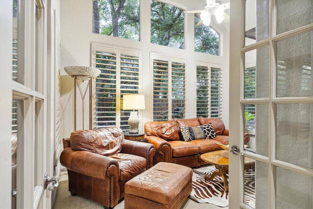 Another view of sunroom with french doors, soaring ceilings, overlooking beautiful trees in back yard.