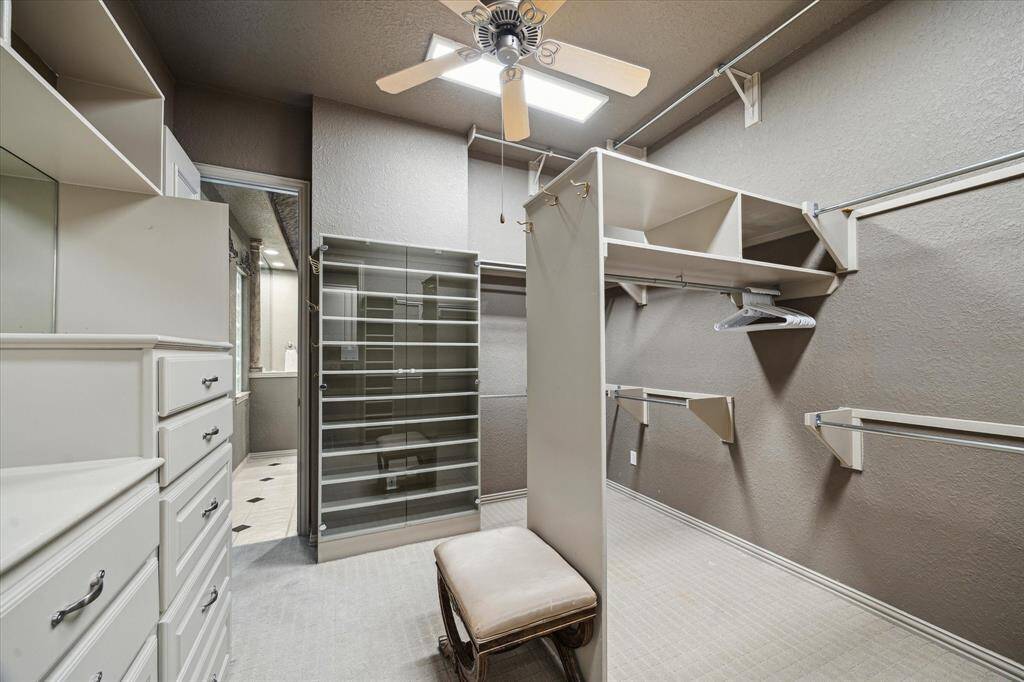 Walk-in two sided master closet with built in dressers and shoe storage, entry from master bath and also into utility room