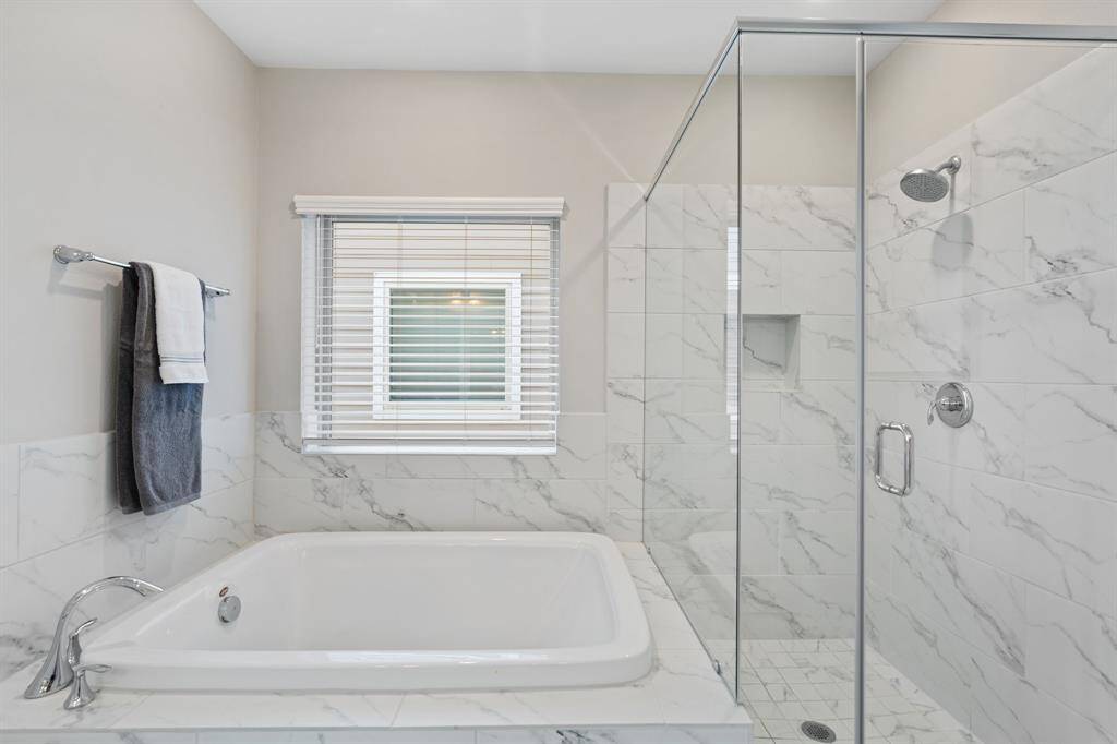 The primary bathroom is a luxurious retreat, designed with both elegance and functionality in mind.