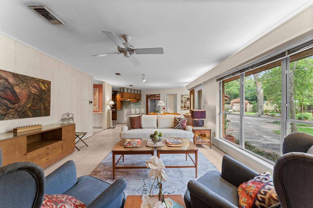 Triple floor to ceiling windows in main living.  Console wall creates space between formal sitting room and this living room.
